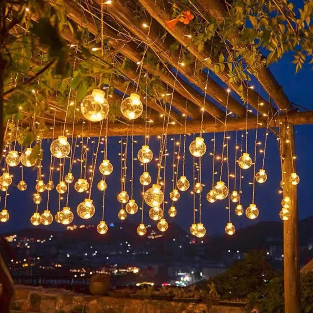 Cortina de luz com bolas suspensas — ambiente acolhedor e mágico 